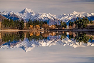 Mountains with snow near lake and sunset